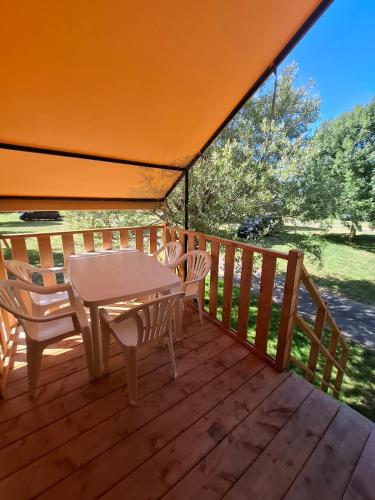 un patio avec une table et des chaises sur une terrasse dans l'établissement Camping Au Bord de Loire, à Gennes