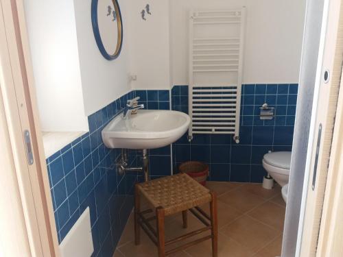 uma casa de banho azul e branca com um lavatório e um WC em L'Arcadia em Giffoni Sei Casali