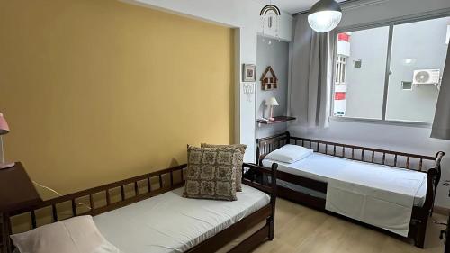 a hospital room with two beds and a window at Apto Almeida e Moraes charmoso passos da praia de BC in Balneário Camboriú