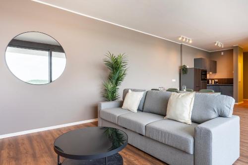 a living room with a couch and a round mirror at Hafen 6 in Zwenkau