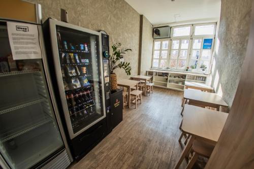 a room with a refrigerator and a table with chairs at Wellness Hostel Central in Prague