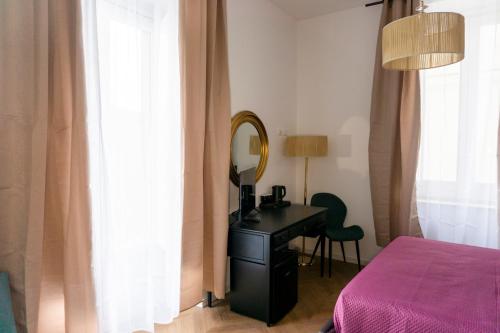 a bedroom with a desk and a mirror and a bed at La Locanda del Sarto in Belmonte Calabro