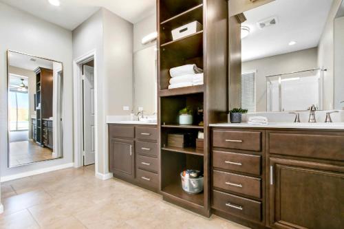 a bathroom with a sink and a large mirror at Spacious Modern Retreat in Palm Desert! in Palm Desert