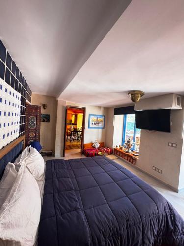 a bedroom with a large bed with a blue blanket at Dar NFis Suites et chambres de luxe dans un havre de paix vue paradisiaque au bord du lac in Lalla Takerkoust