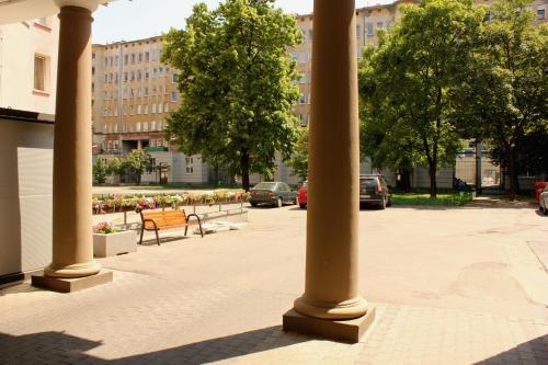 a group of columns in a courtyard with benches at Central Warsaw Apartment in Warsaw