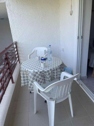 a table with two chairs and a bottle of water on it at Coastal Oasis in Polykhrono