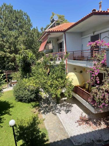a house with a balcony with flowers on it at Coastal Oasis in Polykhrono