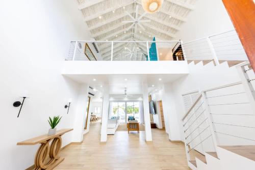 a room with white walls and a white staircase at Caicos Cove Villa 4BR, Pool, 5 mins to Grace Bay in Leeward