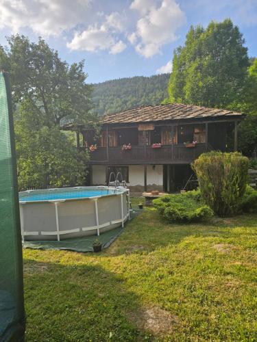 a house with a swimming pool in the yard at Къща за гости Хитър Петър in Apriltsi
