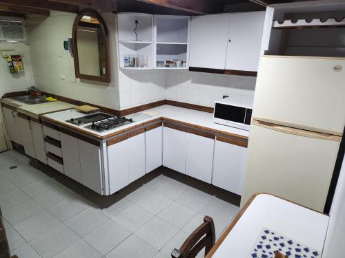 a small kitchen with white cabinets and a sink at TUCACAS VISTA Y SALIDA AL MAR Apto TIPO ESTUDIO DUPLEX SIN HABITACIÓN INDEPENDIENTE in Tucacas