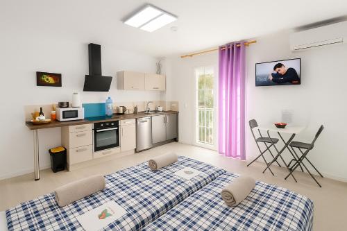 a kitchen with two beds and a table in a room at Fantastico 3 - Grosser Terrasse - Gratis Parkplatz - Klimaanlage - Zentrumsnähe und Meernähe in Puerto de la Cruz