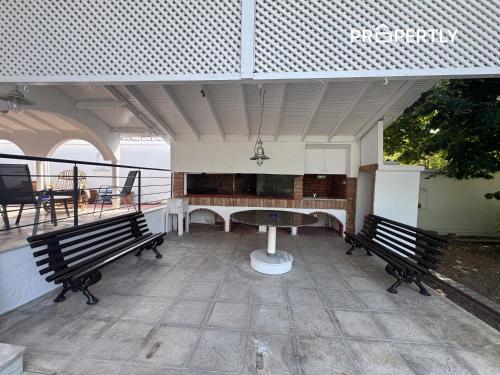 a patio with two benches and a table on a balcony at Casa Clio #PROPERTLY in Nea Kalikratia