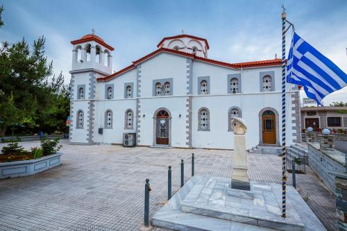 a large white church with a flag in front of it at Bella Vista Apartments in Oktonía