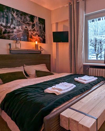 une chambre avec un lit avec deux serviettes dessus dans l'établissement Au Petit Bois, à Chamonix-Mont-Blanc