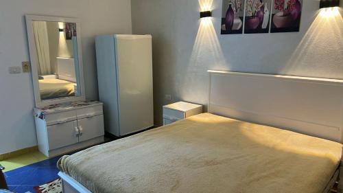 a small bedroom with a bed and a refrigerator at Chalet in Delta Sharm in Sharm El Sheikh