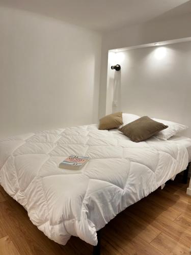 - un lit blanc dans une chambre dotée d'un mur blanc dans l'établissement Appartement LOFT, à Nice