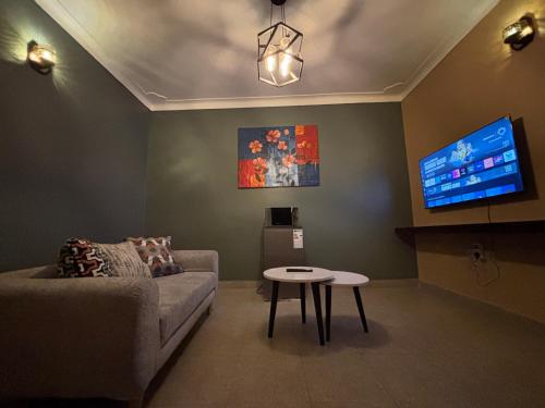 a living room with a couch and a tv at Bukoto Kampala Kickoff Ntinda Luxury apartment in Kampala
