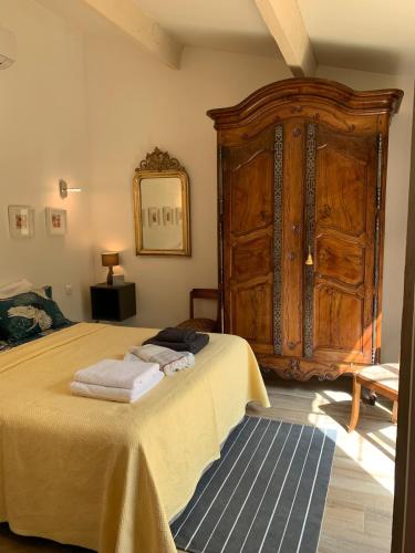 - une chambre avec un lit et une grande armoire en bois dans l'établissement Douillet chic flat & SPA en Provence, à Ventabren