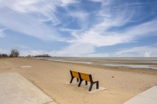 a bench sitting on a beach near the water at 1 Block to Beach Home with Hot Tub in Port Clinton! in Port Clinton