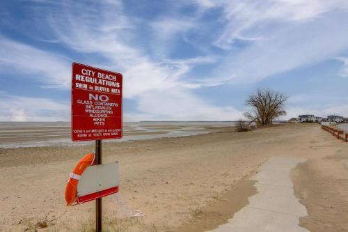 a red sign on a beach next to the water at 1 Block to Beach Home with Hot Tub in Port Clinton! in Port Clinton