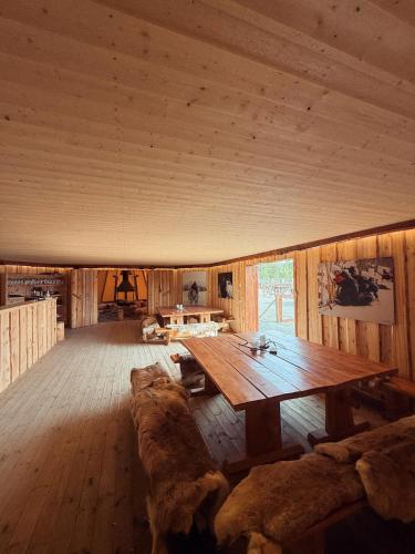 a large room with a wooden table and a couch at Holmen Husky Lodge in Alta