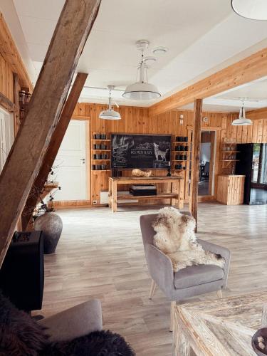 a living room with wooden walls and a large screen tv at Holmen Husky Lodge in Alta