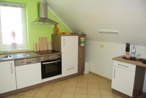 a kitchen with white cabinets and a stove top oven at Seehotel Lindenhof in Lychen