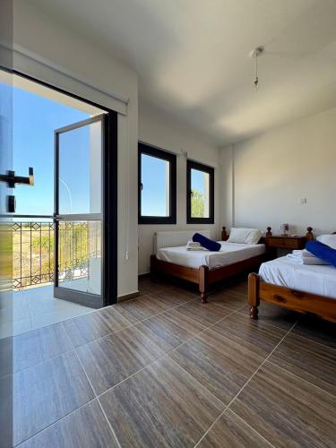 a large room with two beds and a large window at Lazuli Zen Villa with Private Pool in Pyla