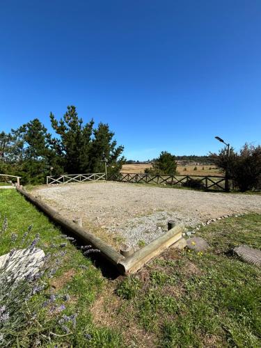 a wooden board in the middle of a field at Cabañas Vista Volcanes del Sur in Llanquihue