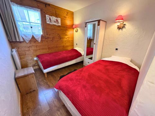 une chambre avec deux lits et un miroir dans l'établissement Chalet Authentique Rénové à St Martin, Terrasse, Proche Pistes et Navette Gratuite - FR-1-452-60, à Saint-Martin-de-Belleville
