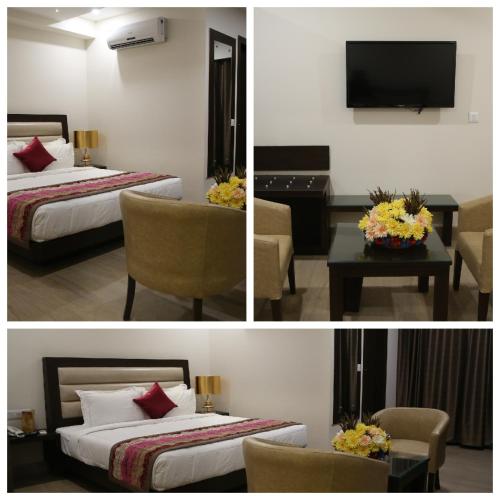 a hotel room with two beds and a desk and a television at Hotel Central Palace in Dehradun
