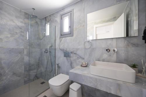 a bathroom with a sink and a toilet and a shower at calmare collection hotel in Plaka
