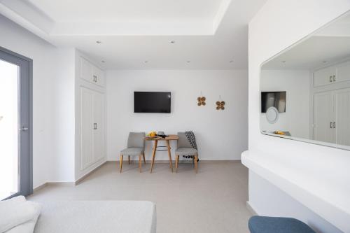 a white living room with a table and chairs at calmare collection hotel in Plaka