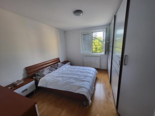 a small bedroom with a bed and a window at Apartma Dejan in Semedela