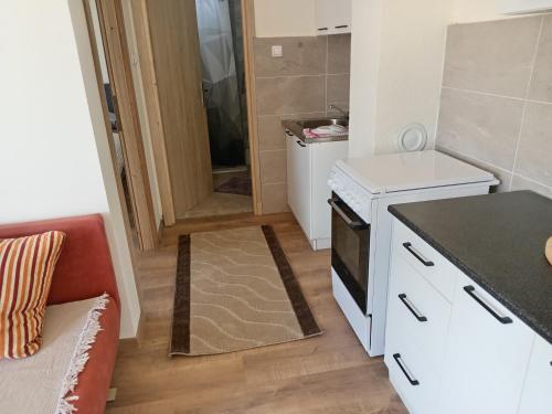 a small kitchen with a stove and a counter top at apartman Tomić in Glamoč