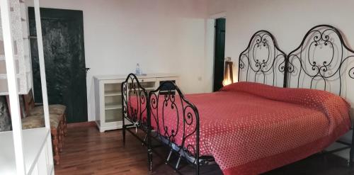 a bedroom with a bed with a red comforter and a fireplace at IL BORGHETTO Room&Breakfast in Rocca San Casciano