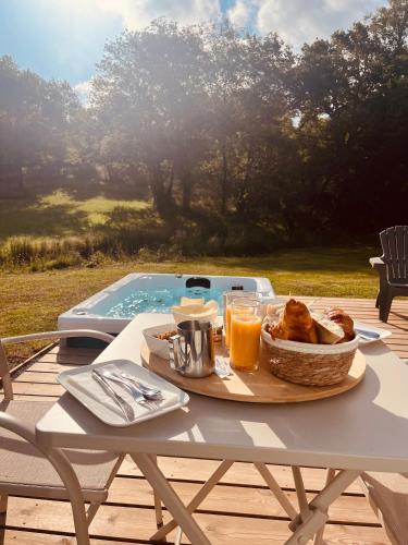 une table avec un plateau de pain et de jus d'orange dans l'établissement Domaine de Chabrague, à Amou