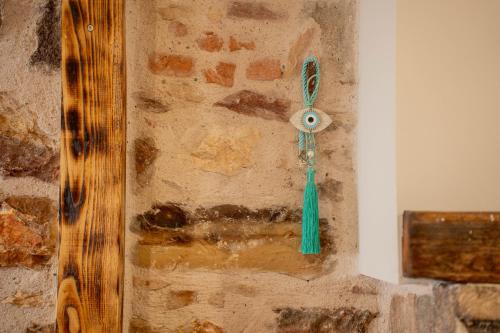 a stone wall with a green tassel on it at Pepita home in Chios