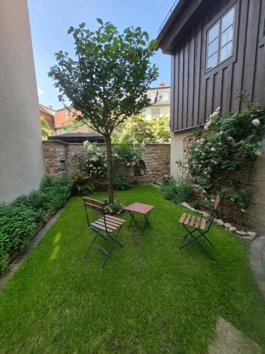 a table and two chairs and a tree in a yard at außergewöhnliches, historisches, spätgotisches Wohnhaus von 1519, Gries 5 in Gera