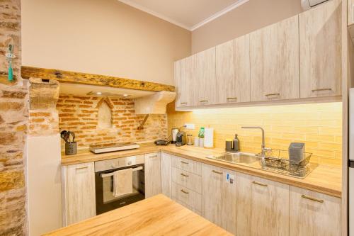 a kitchen with wooden cabinets and a sink at Pepita home in Chios