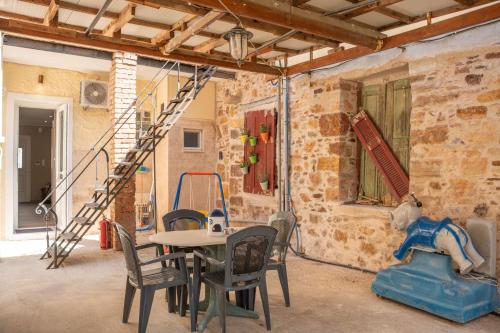 a room with a table and chairs and a staircase at Pepita home in Chios