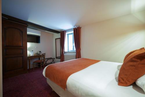 a hotel room with a bed and a desk at Hôtel Wilson - Teritoria in Dijon