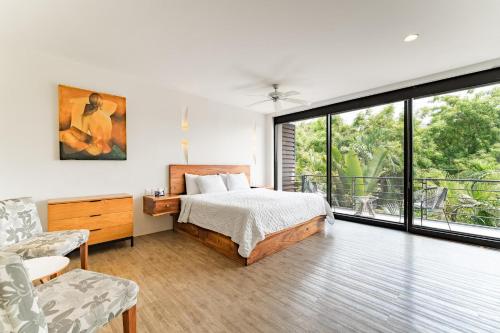 Un dormitorio con una cama y una ventana grande. en 2076 - Mixie 202, en Santa Cruz Huatulco