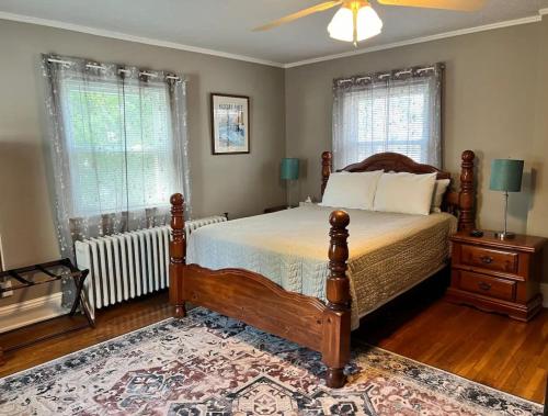 a bedroom with a bed and a fan and windows at Big Historic Home Air Conditioning Parking in Niagara Falls