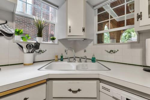 a white kitchen with a sink and windows at Close to the Falls Big Historic Home Air Conditioning Parking in Niagara Falls