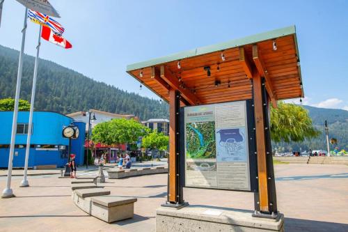 a bus stop with a sign in a park at Beachy 2 Bed Studio Suite, Balcony and 4 Min to Lake in Harrison Hot Springs