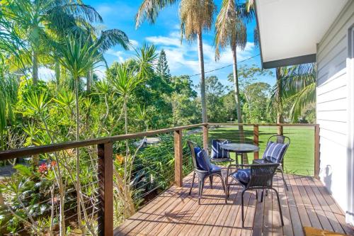 a balcony with chairs and a table and palm trees at South Golden Beach House - Tranquil Family Getaway in South Golden Beach