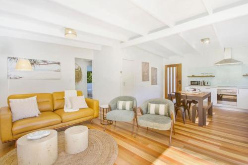 a living room with a yellow couch and a table at South Golden Beach House - Tranquil Family Getaway in South Golden Beach