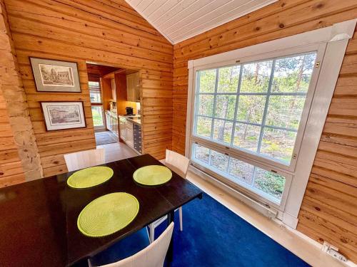 ein Esszimmer mit einem Tisch und einem Fenster in der Unterkunft Villa Mustikka - Modern Log Villa on a Waterfront Estate in Långstrand