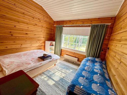 ein Schlafzimmer mit einem Bett in einem Holzzimmer in der Unterkunft Villa Mustikka - Modern Log Villa on a Waterfront Estate in Långstrand
